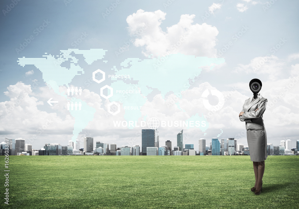 Camera headed woman standing on green grass against modern citys