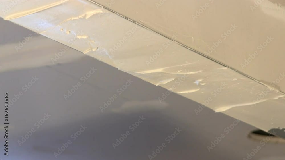 Removing excess joint compound between corner bead of wall opening as