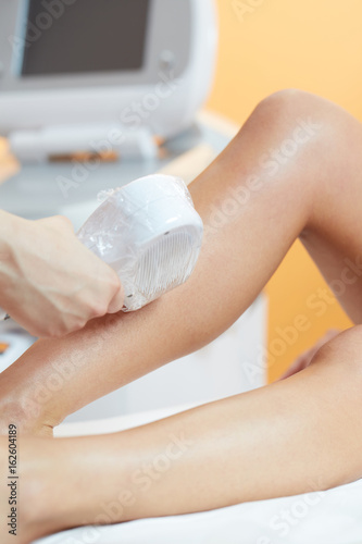 woman at cosmetics salon, legs laser epilation