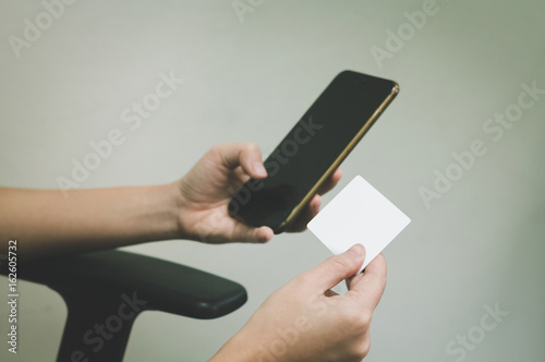  Man's hands holding blank credit card and using smartphone.Online payment on mobile.Online shopping.