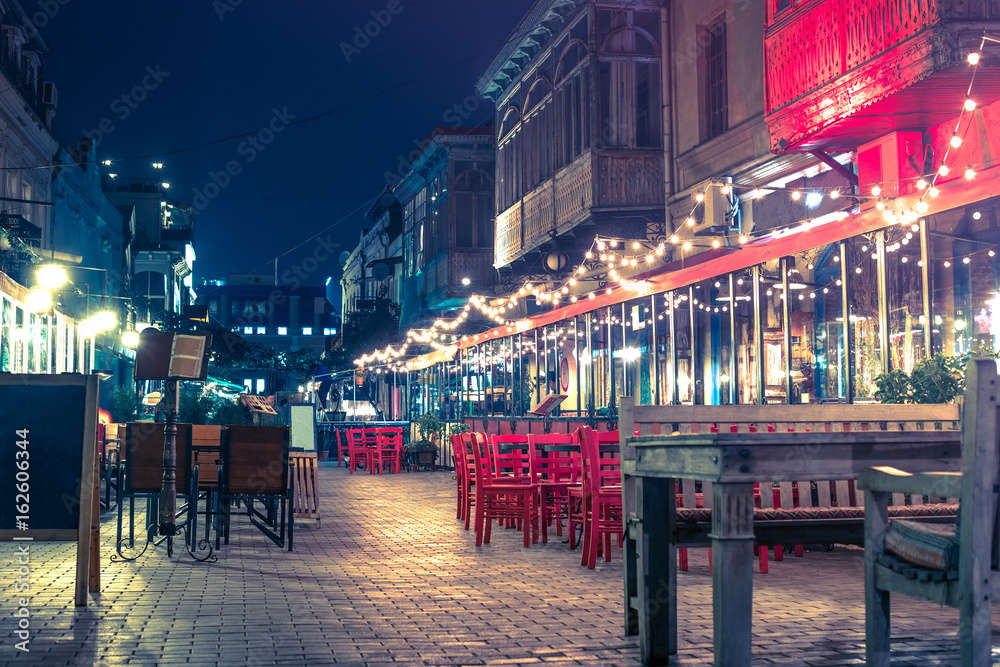beautiful view of illuminated street cafe in Tbilisi at night
