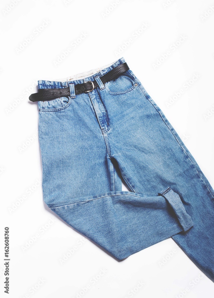 of blue vintage high-waisted mom jeans with black belt isolated on white background. Flat lay.Top Copy space. Stock Photo | Stock