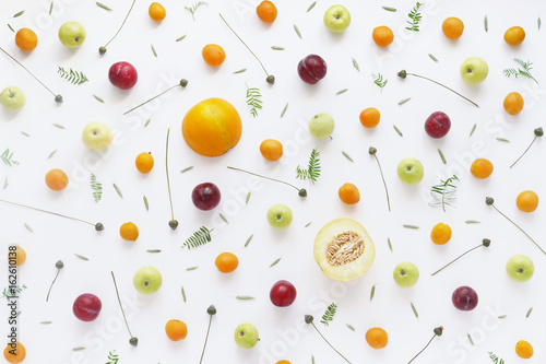 Fruity pattern. Fruits, plants and flowers on a white background. Food background. Top view.