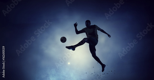 Soccer player with ball outdoors