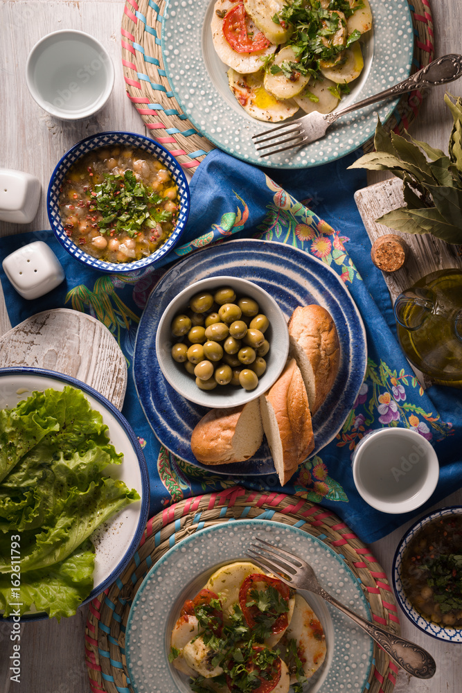 Greek dinner with traditional dishes on the white table vertical Stock