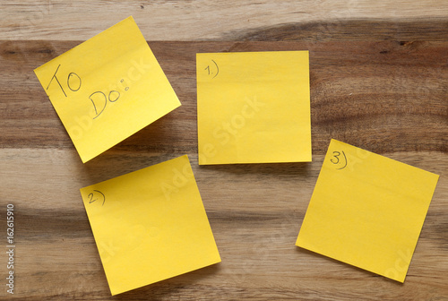 Five post-its numbered one to five on a wooden background. 