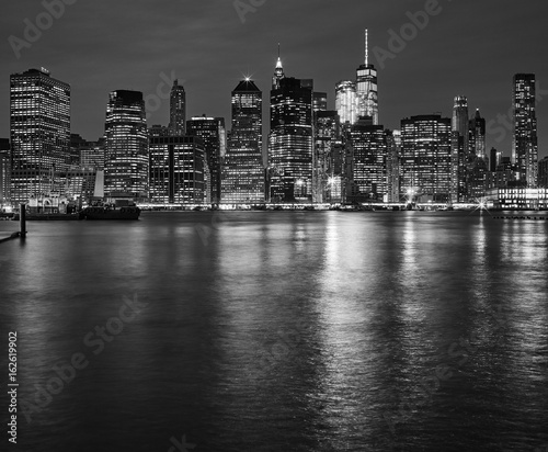 Manhattan skyline reflected in East River at night  New York City  USA.