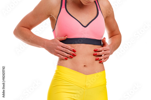 Woman with hands on her flat abs. Fitness concept. Isolated on white background