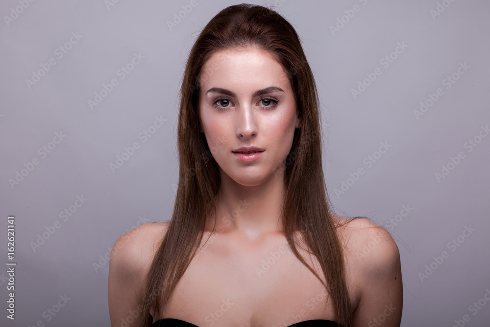 Beautiful fresh woman with no makeup in studio photo on gray background in studio photo. Beauty and fashion. Beautiful fresh woman with no makeup in studio photo on gray background in studio photo. Beauty and fashion.