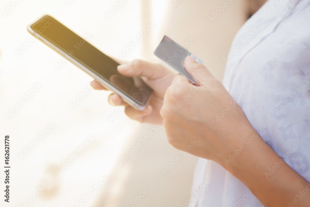 woman asian using phone and credit card shopping online , selective focus on hand woman asian using phone and credit card shopping online , selective focus on hand