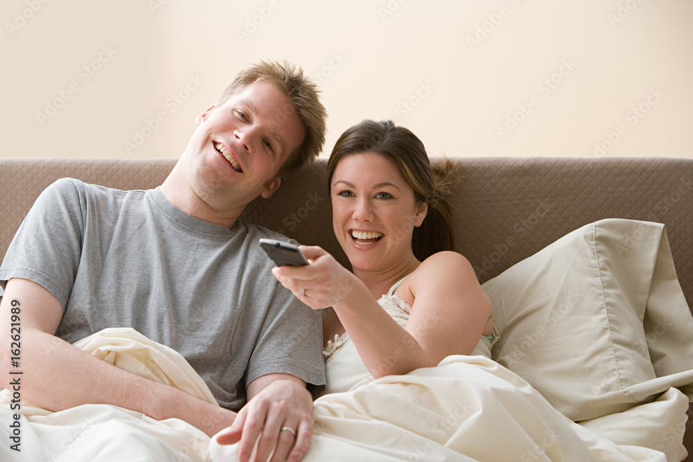 Fotografie Couple watching television in bed