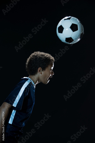 Tablou pe pânză Boy heading a football