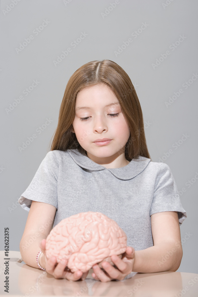 Fotografie Girl holding a model brain