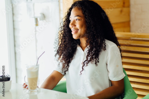 Portrait of a young afro american woman enjoying cup of coffee in coffee shop