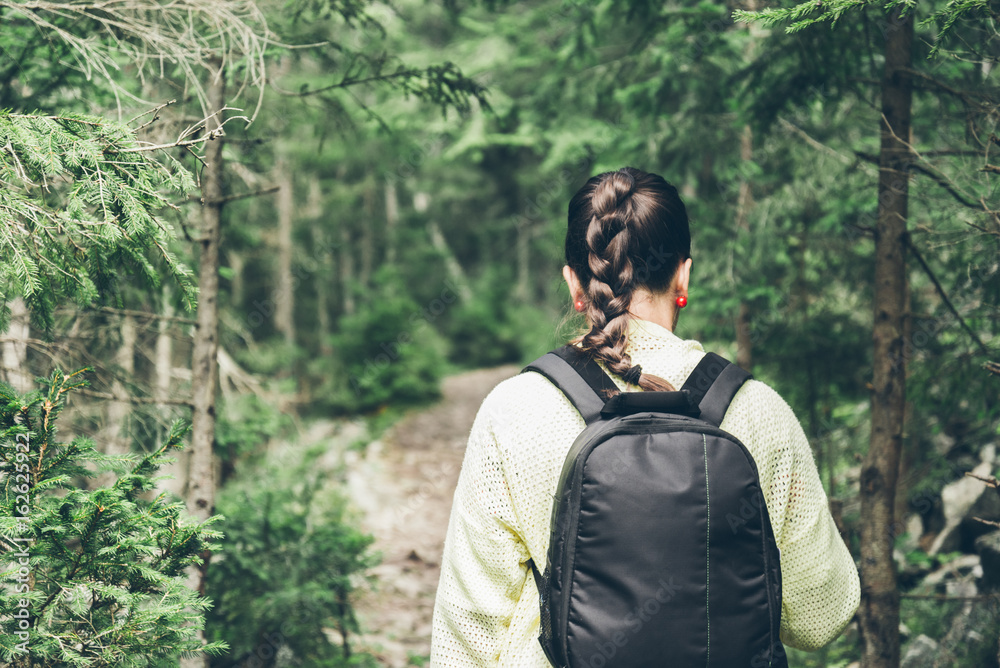 Young lady hiker with backpack walking in carpathian