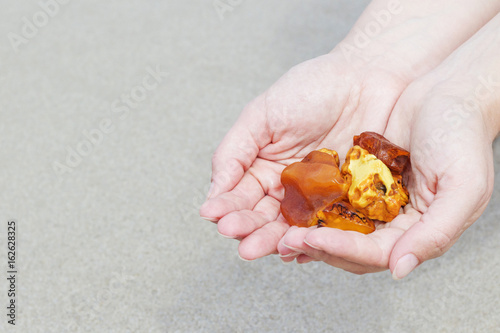 Amber in the hand with a bright reflection on the palm against the background of the sea. photo