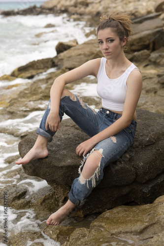 Teenage girl sitting on the rocks. © FRANCISGONSA