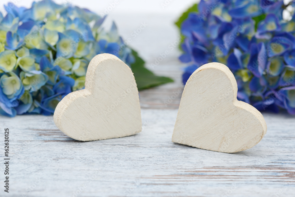 Obraz premium blue flower and wooden heart lying on wood