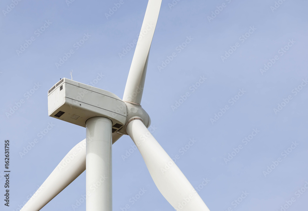 close up of Wind Turbine producing alternative energy with blue sky background close up of Wind Turbine producing alternative energy with blue sky background