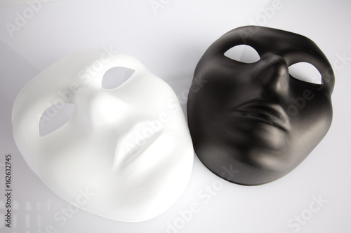 Black and white masks on white surface  - looking upwards
