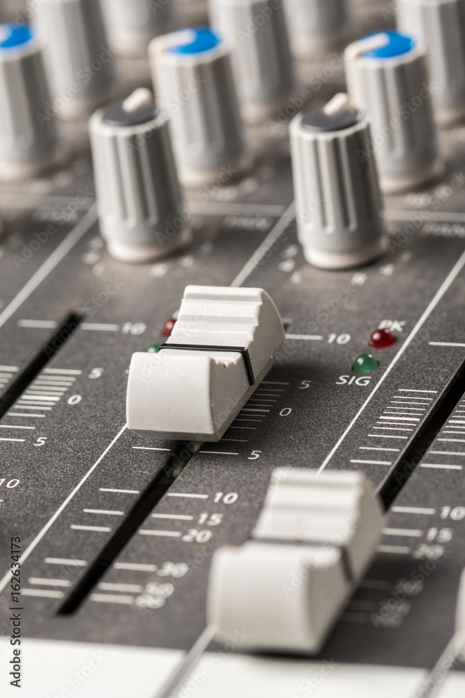 Closeup macro audio mixing console knobs and sliders. Closeup macro audio mixing console knobs and sliders.