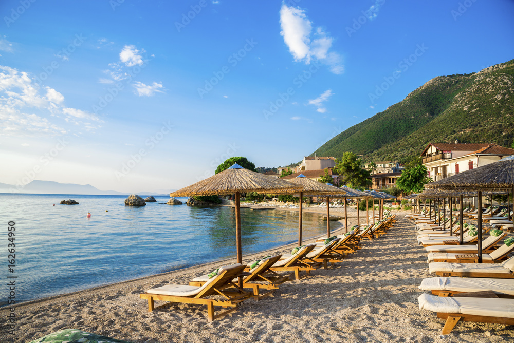 Beautiful beach with chairs and unbrellas in Nikiana village, Lefkada, Greece