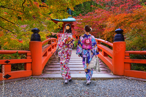 Fototapeta Kobiety w kimonach chodzi przy kolorowymi klonowymi drzewami w jesieni, Kyoto. Japonia