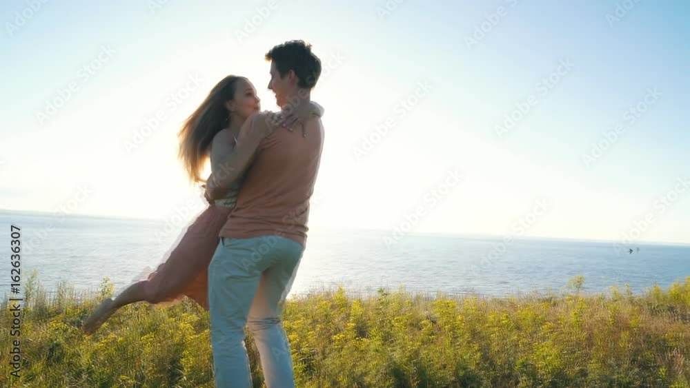 happy couple dancing at the edge of the cliff on the background of the river happy couple dancing at the edge of the cliff on the background of the river