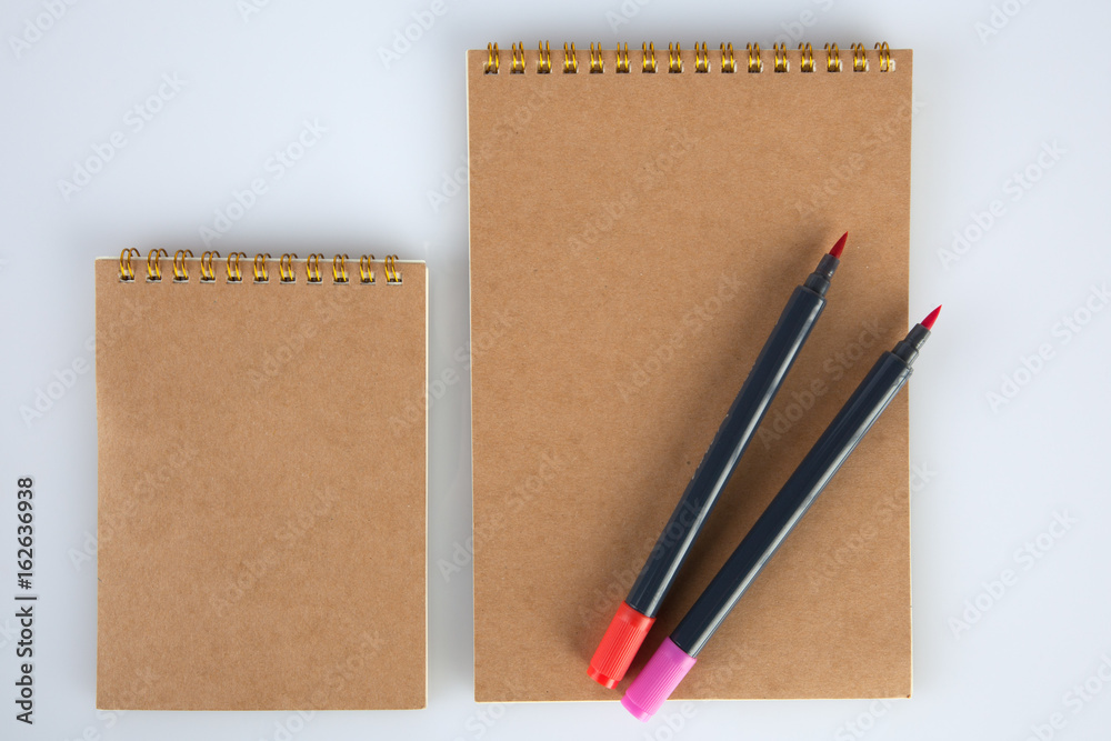 Two spiral notepads big and small with two markers for mockups. Top view with copy space Two spiral notepads big and small with two markers for mockups. Top view with copy space