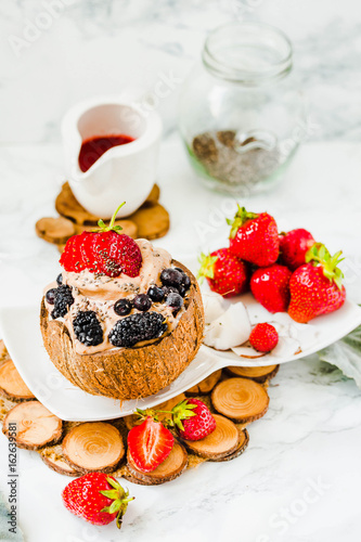 Chocolate ice cream with berries on coconut cup.Healthy vegetarian meal concept.