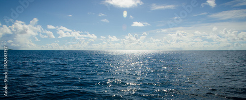 A panoramic scene of blue sky and the ocean with sunbeam shine above © kevinlert