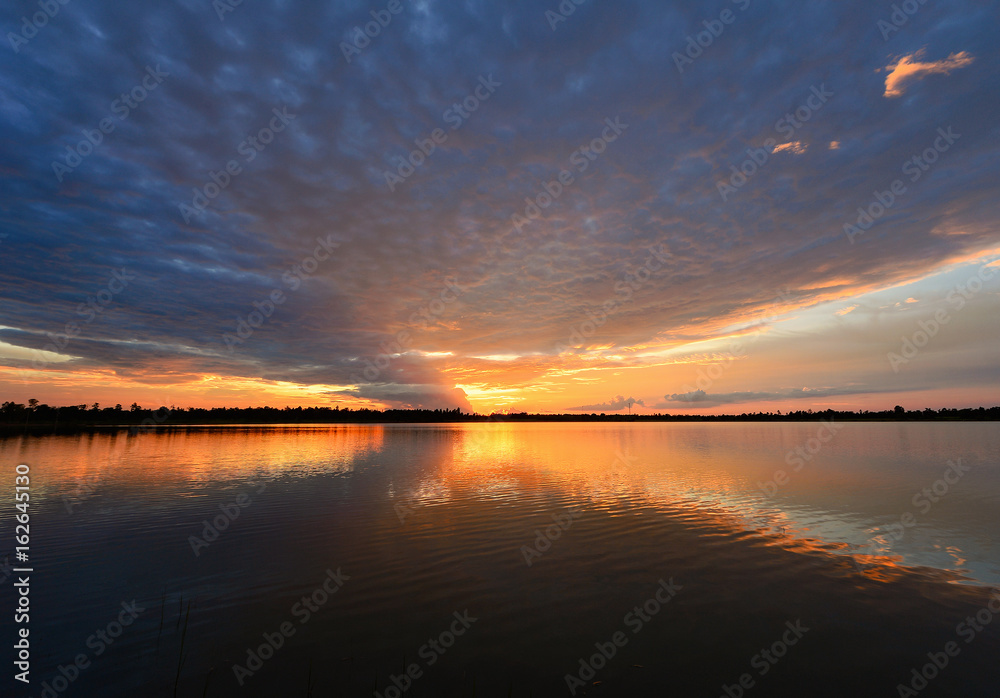 Cumulus sunset clouds with sun setting down Cumulus sunset clouds with sun setting down