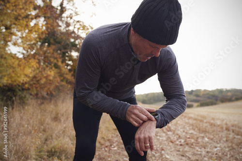 Mature Man On Autumn Run Around Field Checks Activity Tracker