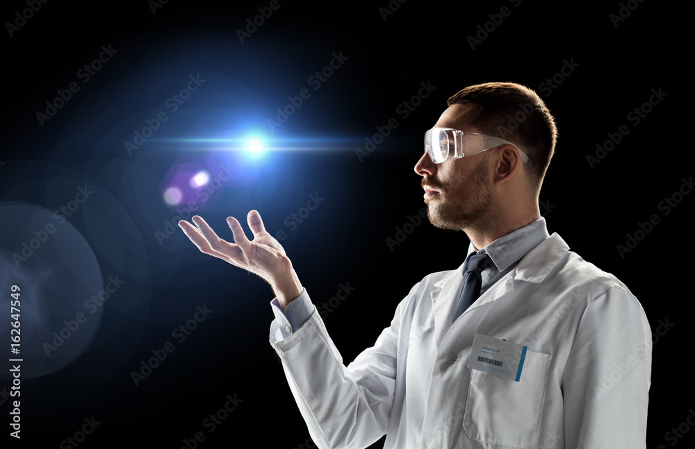 scientist in lab coat and goggles with laser light scientist in lab coat and goggles with laser light
