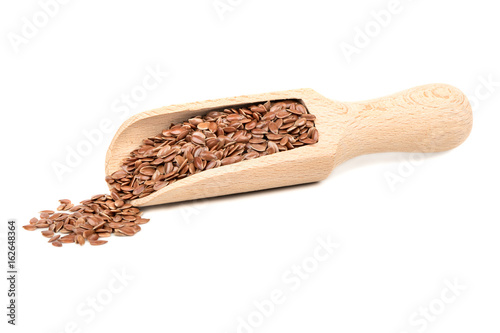 Flax seed in wooden scoop on white background