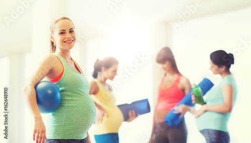 Fototapeta Naklejka Na Ścianę i Meble -  happy pregnant woman with ball in gym