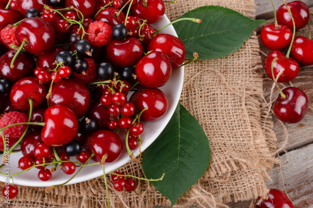 Mature berries on a plate on a wooden table Mature berries on a plate on a wooden table