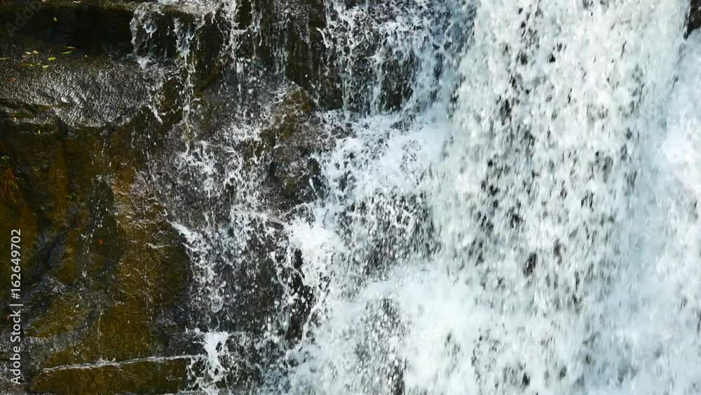 Close up Waterfalls in the rainy season. There is a lot of water flowing into the stones. In the forests of the National Park, include The sound of waterfall.