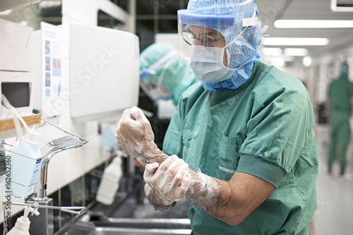Surgeon washing hands and arms before surgery photo