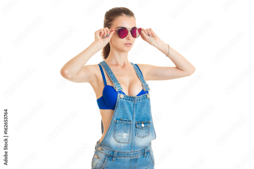 Sexy lady in jeans overall and blue bra with big silicon tits