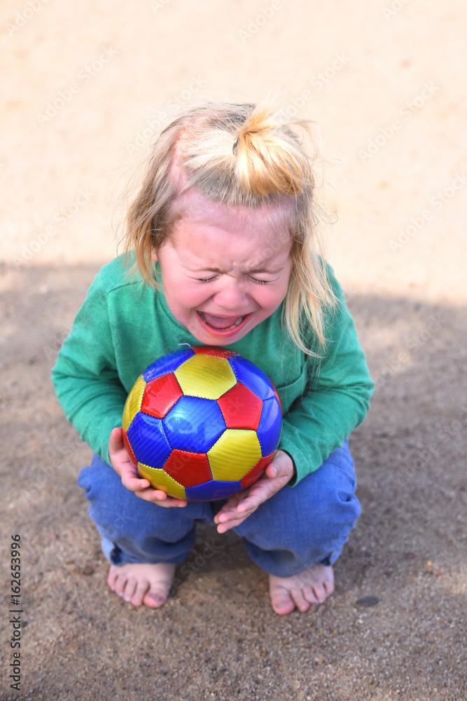 Boy little adorable kid crying sitting with ball Boy little adorable kid crying sitting with ball