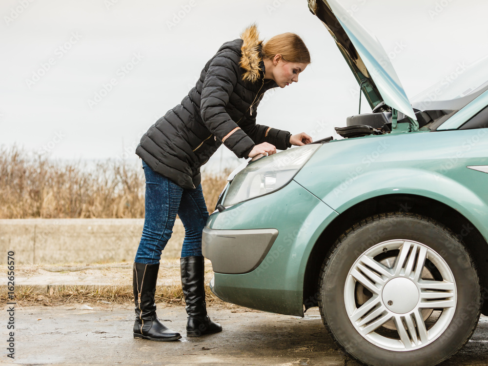 Blonde woman and broken down car on road Blonde woman and broken down car on road