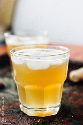 Ginger beer in glass on black rustic surface