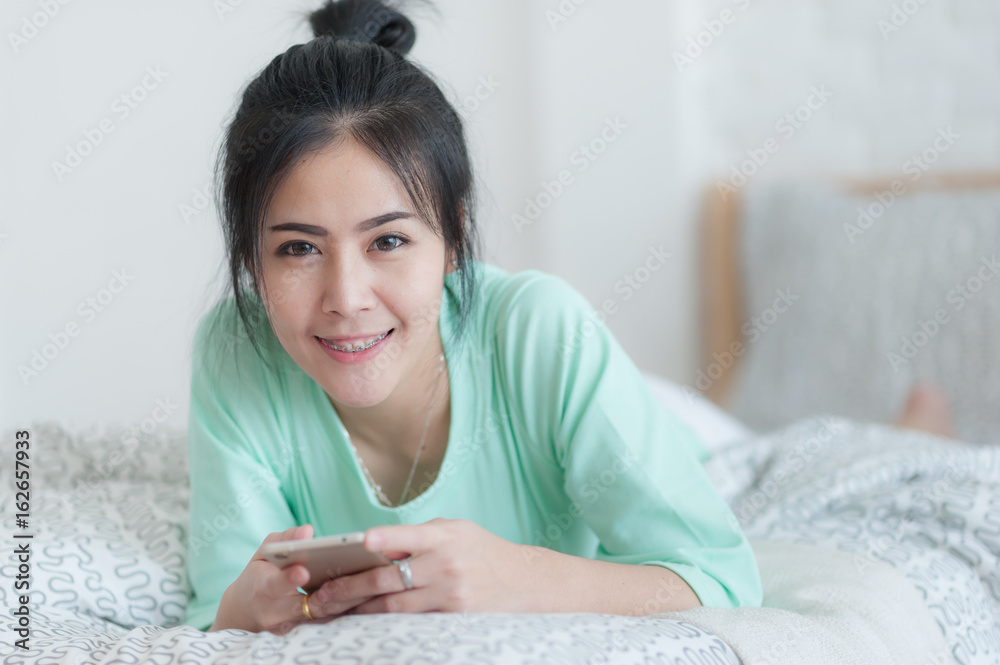 Young Asian woman stretching on bed after wake up Young Asian woman stretching on bed after wake up
