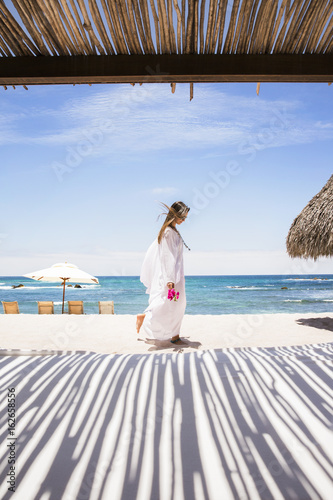 Woman walking on white sand beach