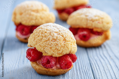 Eclairs with mascarpone cream and raspberries. photo