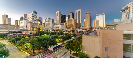 Aerial view downtown Houston illuminated at twilight with green city park and modern skylines light. The most populous city in Texas, fourth-most in United States. Architecture and travel background.