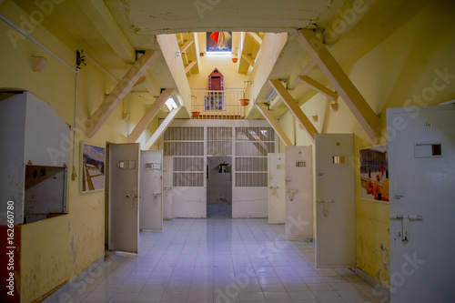 Fotografía Indoor view of old deserted rugged building, cells of prisoners with doors open