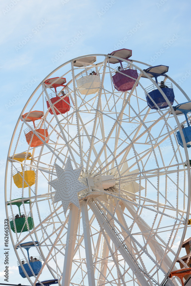 Ferris wheel against the blue sky Ferris wheel against the blue sky