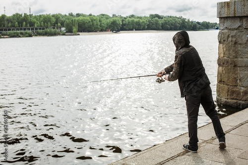 Young man fishing with a spinning on the river